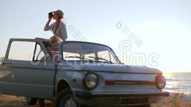 女朋友在靠近海岸河流的车辆的手机上<strong>录制</strong>视频，年轻女孩用机器拍照到智能手机，
